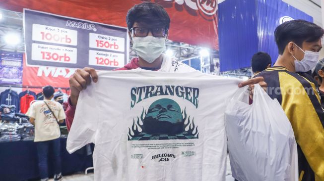 Pengunjung memilih pakaian di event Jakarta Clothing (JakCloth) 2021 di JCC Senayan, Jakarta Pusat, Minggu (12/12/2021). [Suara.com/Alfian Winanto]