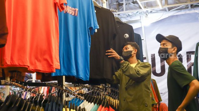Pengunjung memilih pakaian di event Jakarta Clothing (JakCloth) 2021 di JCC Senayan, Jakarta Pusat, Minggu (12/12/2021). [Suara.com/Alfian Winanto]
