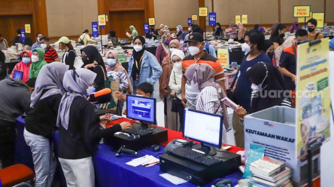 Antrian pengunjung yang membeli buku di pameran Indonesia Internationa Book Fair (IIBF) 2021 di JCC Senayan, Jakarta Pusat, Minggu (12/12/2021). [Suara.com/Alfian Winanto]
