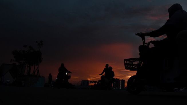 Warga menyaksikan matahari tenggelam saat mengunjungi kawasan Pantai Maju, Pantai Indah Kapuk (PIK), Kamal Muara, Jakarta, Sabtu (11/12/2021). ANTARA FOTO/Wahyu Putro 