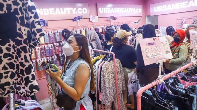 Pengunjung memilih pakaian di event Jakarta Clothing (JakCloth) 2021 di JCC Senayan, Jakarta Pusat, Minggu (12/12/2021). [Suara.com/Alfian Winanto]