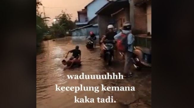 Gara-gara nekat terjang genangan banjir, pemotor bingung motornya nyemplung ke sungai (TikTok)