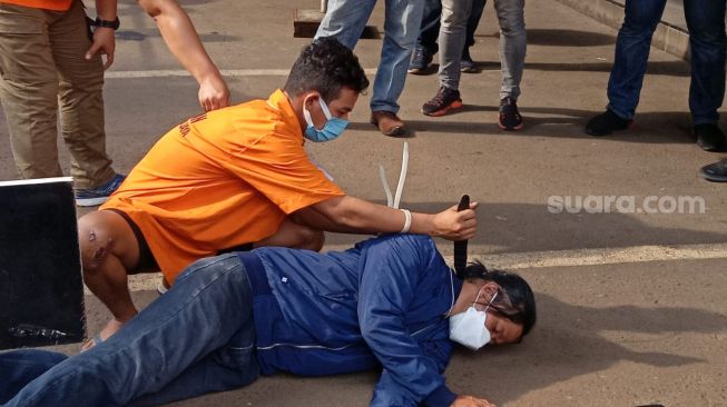 Polisi menggelar rekonstruksi pembunuhan tunawicara Yossi Mahesa (31) di Kemayoran, Jakarta Pusat. Pelaku Adji Subhi (12) memeragakan 12 adegan dalam rekonstruksi yang dilakukan di Polda Metro Jaya, Senin (13/12/2021). [Suara.com/Muhammad Yasir]