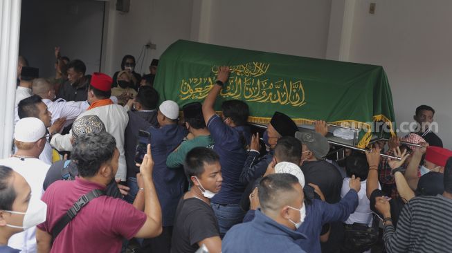 Keluarga dan kerabat mengusung peti jenazah almarhum politikus senior Abraham Lunggana atau Haji Lulung setibanya di rumah duka di kawasan Sukabumi Utara, Kebon Jeruk, Jakarta, Selasa (14/12/2021). [Suara.com/Angga Budhiyanto]