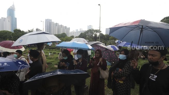 Sejumlah pelayat berada di dekat pusara almarhum politikus senior Abraham Lunggana atau Haji Lulung di TPU Karet Bivak, Jakarta, Selasa (14/12/2021). [Suara.com/Angga Budhiyanto]