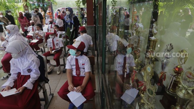 Sejumlah pelajar menunggu untuk mendapatkan vaksin COVID-19 di SDN 04 Cilandak Barat, Jakarta, Selasa (14/12/2021). [Suara.com/Angga Budhiyanto]