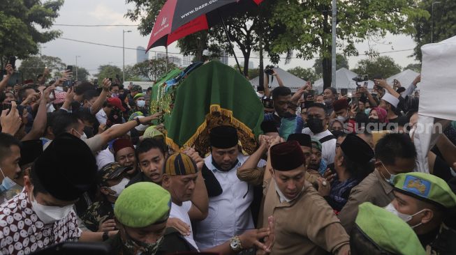 Keluarga dan kerabat mengusung peti jenazah almarhum politikus senior Abraham Lunggana atau Haji Lulung di TPU Karet Bivak, Jakarta, Selasa (14/12/2021). [Suara.com/Angga Budhiyanto]