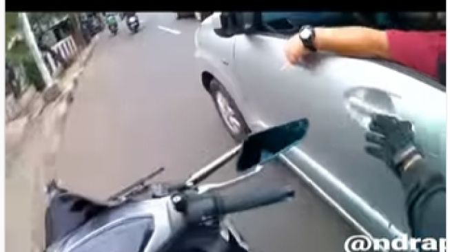 Pemotor hendak mematikan rokok dari penumpang mobil (Instagram)