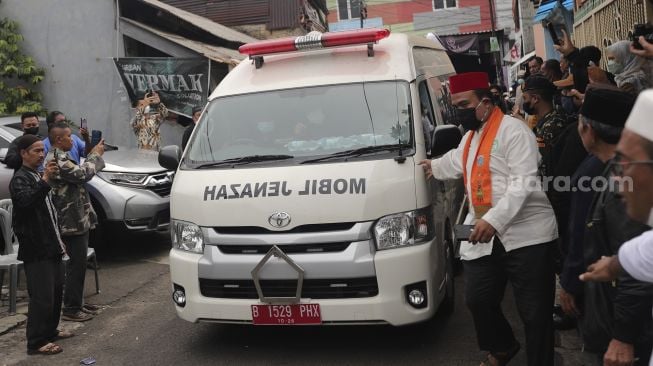 Mobil ambulans yang membawa jenazah almarhum politikus senior Abraham Lunggana atau Haji Lulung tiba di rumah duka di kawasan Sukabumi Utara, Kebon Jeruk, Jakarta, Selasa (14/12/2021). [Suara.com/Angga Budhiyanto]