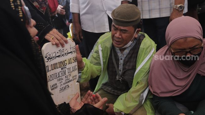 Keluarga dan kerabat berdoa di pusara almarhum politikus senior Abraham Lunggana atau Haji Lulung di TPU Karet Bivak, Jakarta, Selasa (14/12/2021). [Suara.com/Angga Budhiyanto]