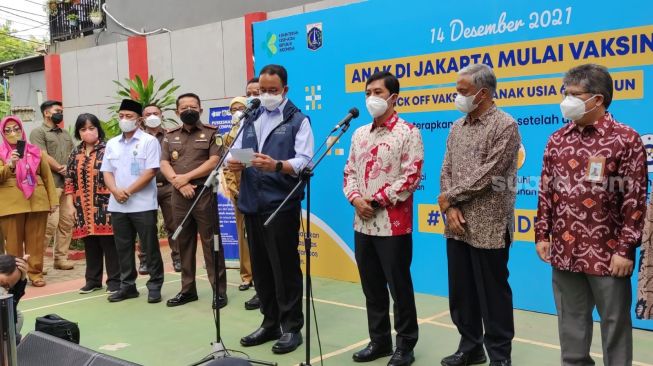 Gubernur DKI Jakarta Anies Baswedan melakukan peninjauan langsung pelaksanaan pertama kali atau kick off vaksinasi Covid-19 untuk anak usia 6-11 tahun di SDN 03 Pagi Cempaka Putih Timur, Selasa (14/12/2021). (Suara.com/Fakhri)