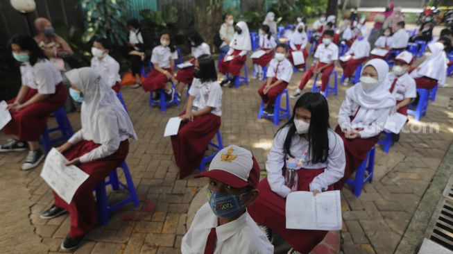 Sejumlah pelajar menunggu untuk mendapatkan vaksin COVID-19 di SDN 04 Cilandak Barat, Jakarta, Selasa (14/12/2021). [Suara.com/Angga Budhiyanto]