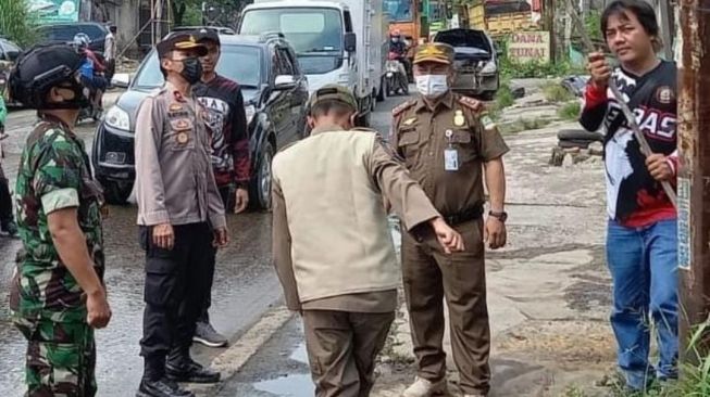 Petugas gabungan membersihkan atribut ormasi di Wilayah Cikarang, Selasa (14/12/2021)