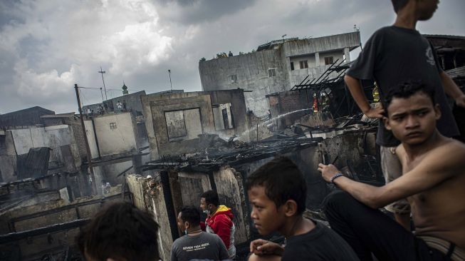 Sejumlah warga melihat kondisi rumah mereka pascakebakaran di permukiman padat penduduk Kramat Pulo, Senen, Jakarta, Rabu (15/12/2021).  ANTARA FOTO/Aprillio Akbar