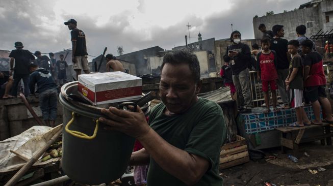 Warga mencari barang berharga miliknya pascakebakaran di permukiman padat penduduk Kramat Pulo, Senen, Jakarta, Rabu (15/12/2021). ANTARA FOTO/Aprillio Akbar