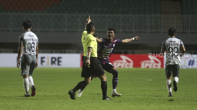 Pemain belakang RANS Cilegon FC  Alfin Tuasalamony melakukan protes terhadap wasit selama pertandingan grup X babak 8 besar Liga 2 antara RANS Cilegon FC melawan Persis Solo di Stadion Pakansari, Bogor, Jawa Barat, Rabu (15/12/2021). [Suara.com/Angga Budhiyanto]