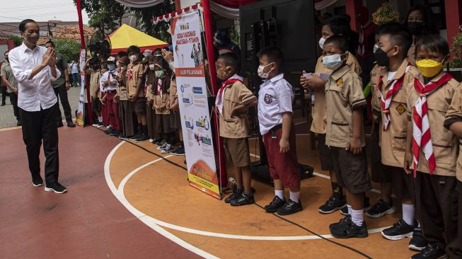 Presiden Joko Widodo (kiri) menyapa sejumlah siswa sekolah dasar yang akan mendapatkan vaksinasi COVID-19 di Kompleks SDN Cideng, Gambir, Jakarta Pusat, Rabu (15/12/2021). ANTARA FOTO/Sigid Kurniawan
