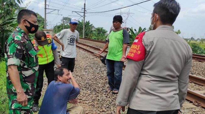 Petugas menyelidiki kasus tewasnya pengendara motor bernama Indra yang tersambar KRL di Kecamatan Cisauk, Kabupaten Tangerang, Rabu (15/12/2021). [Dok. Polsek Cisauk]