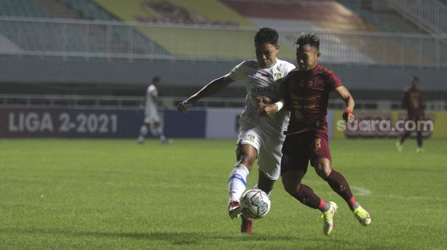 Gelandang Sriwijaya FC Hari Habrian (kanan) berebut bola dengan pemain belakang Persiba Balikpapan Imam Mahmudi selama pertandingan grup X babak 8 besar Liga 2 antara Sriwijaya FC melawan Persiba Balikpapan di Stadion Pakansari, Bogor, Jawa Barat, Rabu (15/12/2021). [Suara.com/Angga Budhiyanto]