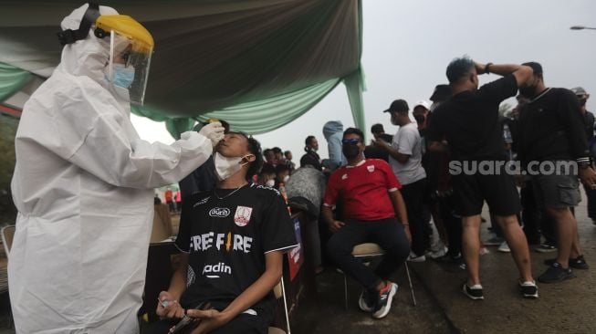 Tenaga kesehatan melakukan tes usap antigen kepada suporter yang akan memasuki Stadion Pakansari, Cibinong, Kabupaten Bogor, Jawa Barat, Rabu (15/12/2021). [Suara.com/Angga Budhiyanto]