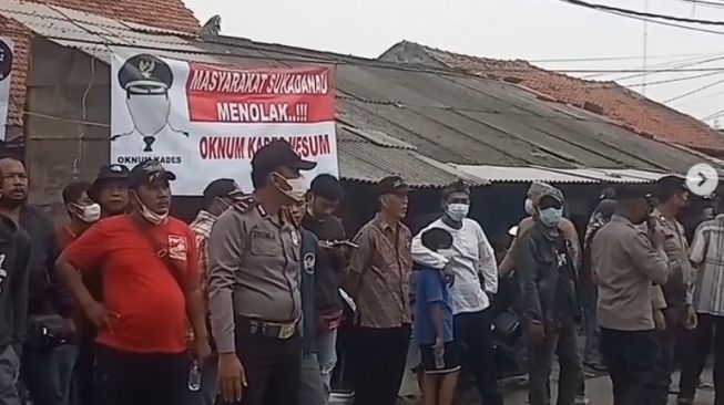 Petugas berjaga di sekitar area Kantor Kepala Desa Sukadanau Kecamatan Cikarang Barat, Rabu (15/12/2021). [Instagram]