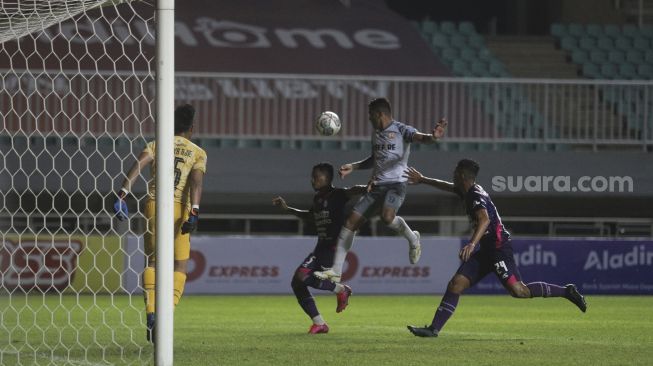 Penyerang Persis Solo Alberto Goncalves (tengah) berusaha menjangkau bola selama pertandingan grup X babak 8 besar Liga 2 antara RANS Cilegon FC melawan Persis Solo di Stadion Pakansari, Bogor, Jawa Barat, Rabu (15/12/2021). [Suara.com/Angga Budhiyanto]