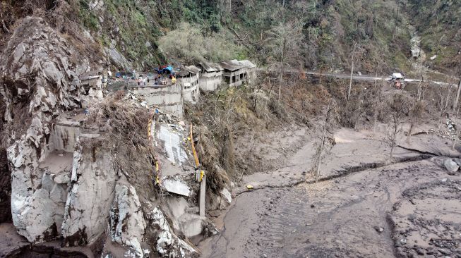 Foto udara kondisi jembatan Besuk Koboan (Gladak Perak) yang terputus akibat tersapu lahar hujan Gunung Semeru di Kamar Kajang, Candipuro, Lumajang, Jawa Timur, Rabu (15/12/2021).  ANTARA FOTO/Budi Candra Setya