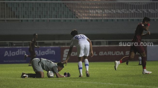 Penjaga gawang Persiba Balikpapan Riki Pambudi mengamankan bola selama pertandingan grup X babak 8 besar Liga 2 antara Sriwijaya FC melawan Persiba Balikpapan di Stadion Pakansari, Bogor, Jawa Barat, Rabu (15/12/2021). [Suara.com/Angga Budhiyanto]