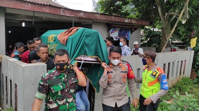 Petugas dan warga mengangkat keranda jenazah Indra yang tewas tersambar KRL di Kecamatan Cisauk, Kabupaten Tangerang, Rabu (15/12/2021). [Dok. Polsek Cisauk]