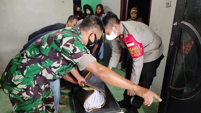 Petugas bersiap membantu pemakaman Indra yang tersambar KRL di Kecamatan Cisauk, Kabupaten Tangerang, Rabu (15/12/2021). [Dok. Polsek Cisauk]