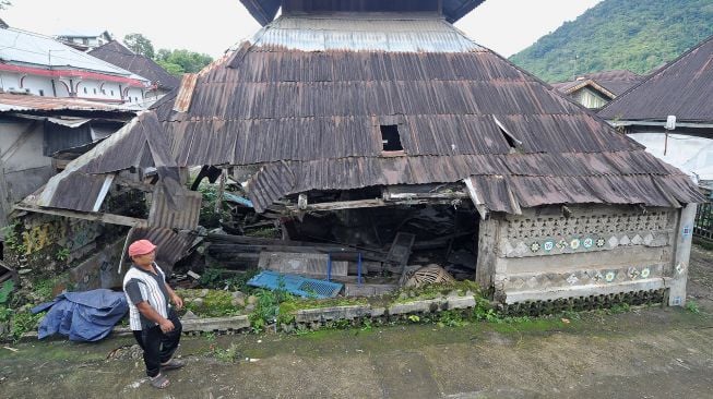 Warga melintas di samping Masjid Kuno Lempur yang terbengkalai di Lempur Hilir, Gunung Raya, Kerinci, Jambi, Kamis (16/12/2021).  ANTARA FOTO/Wahdi Septiawan