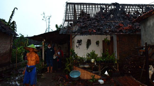 Sejumlah orang berada di dekat bangunan rumah yang rusak akibat puting beliung di Wonoasri, Kabupaten Madiun, Jawa Timur, Rabu (15/2/2021).  ANTARA FOTO/Siswowidodo