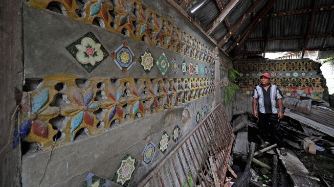 Warga menunjukkan corak seni ukir khas dan tempelan keramik kuno yang terdapat di bagian dalam Masjid Kuno Lempur yang terbengkalai di Lempur Hilir, Gunung Raya, Kerinci, Jambi, Kamis (16/12/2021). ANTARA FOTO/Wahdi Septiawan
