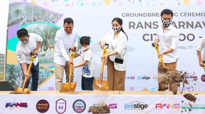 Presenter Raffi Ahmad (kedua kiri) ditemani putranya, Rafathar dan sang istri, Nagita Slavina dan juga Presiden Direktur Prestige Motorcars Rudy Salim (kedua kanan) saat acara Groundbreaking RANS Carnival Zoo di Pantai Indah Kapuk 2, Banten, Jumat (17/12/2021). [Suara.com/Alfian Winanto]