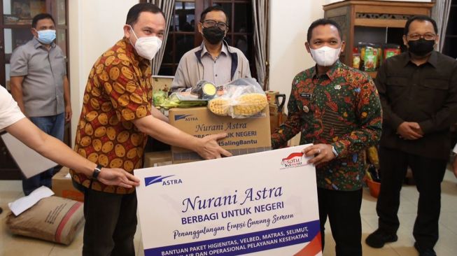 Menteri Koordinator Bidang Politik, Hukum, dan Keamanan Republik Indonesia Mahfud MD (tengah) menyaksikan penyerahan bantuan untuk korban bencana alam erupsi Gunung Semeru dari Astra yang diwakili oleh Chief of Corporate Affairs Astra Riza Deliansyah (kiri) kepada Bupati Lumajang Thoriqul Haq (kanan) pada hari ini (17/12) yang berlokasi di pendopo Kabupaten Lumajang [Grup Astra].