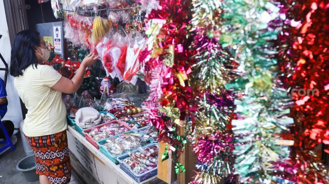 Pengunjung memilih pernak-pernik Natal di Pasar Asemka, Jakarta Barat, Sabtu (18/12/2021). [Suara.com/Alfian Winanto]