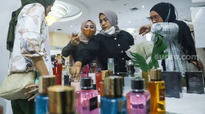 Pengunjung memilih parfum di acara Muslima Festival 2021 di Smesco Indonesia, Jakarta Selatan, Sabtu (18/12/2021). [Suara.com/Alfian Winanto]