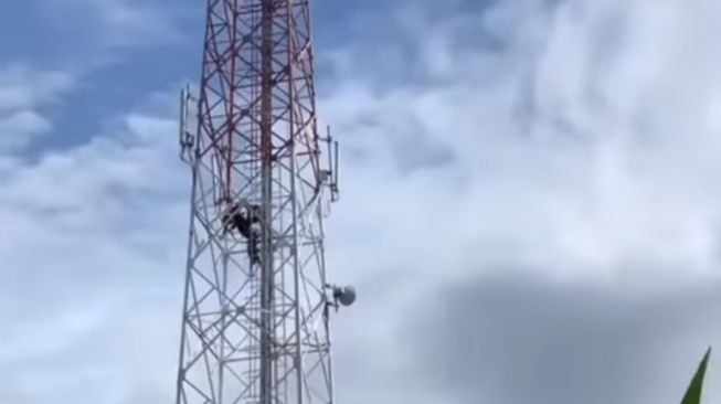 Tangkapan layar pemuda nekat tiduri tower 80 meter karena putus cinta. [Instagram]