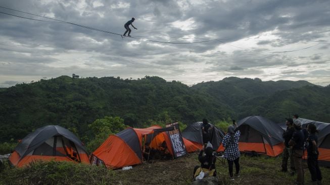 Pegiat olahraga ekstrem berjalan di atas tali webbing pada kegiatan Bandung Highlines Festival di Tebing Hawu, Kabupaten Bandung Barat, Sabtu (18/12/2021). [ANTARA FOTO/Novrian Arbi]