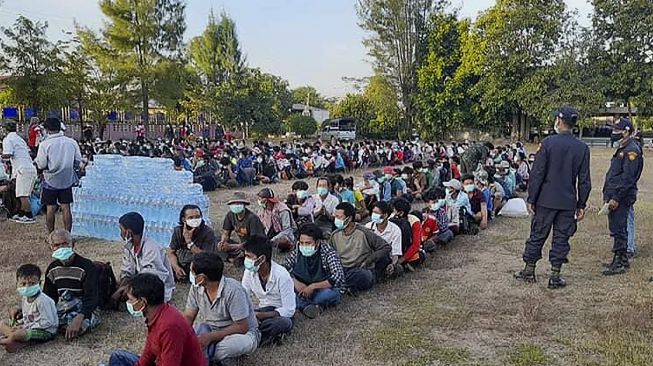 Pengungsi dari Myanmar yang melarikan diri dari gelombang kekerasan duduk dalam antrean saat mereka diproses di Mae Tao Phae, distrik Mae Sot, Thailand, pada (16/12/2021). [HANDOUT / METTA CHARITY / AFP]