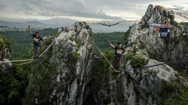 Pegiat olahraga ekstrem berjalan di atas tali webbing pada kegiatan Bandung Highlines Festival di Tebing Hawu, Kabupaten Bandung Barat, Sabtu (18/12/2021). [ANTARA FOTO/Novrian Arbi]