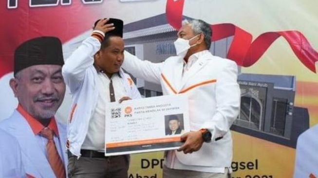 Presiden PKS Ahmad Syaikhu memaikan peci dan menyerahkan KTA kepada Narji, Miniggu (19/12/2021)