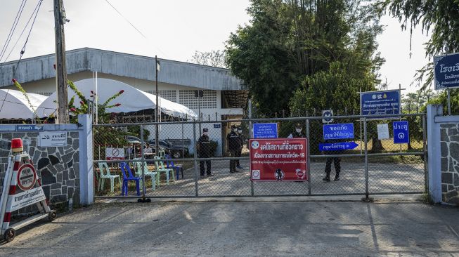 Petugas berdiri di gerbang tempat penampungan sementara penampungan pengungsi Myanmar yang melarikan diri dari rumah mereka di tengah gelombang kekerasan, di distrik Mae Sot, Thailand, pada (18/12/2021). [AFP]