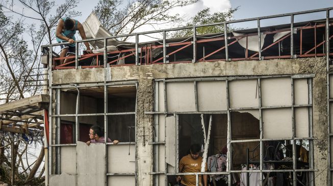 Warga memeriksa rumah mereka yang hancur di Kota Surigao, Provinsi Surigao del Norte, Filipina, pada (19/12/2021). [FERDINANDH CABRERA / AFP]