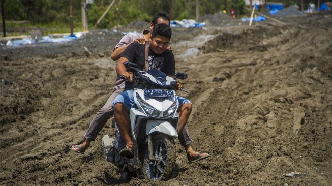 Pengendara sepeda motor melintas di jalan Trans Kalimantan yang rusak di Kecamatan Liang Anggang, Banjarbaru, Kalimantan Selatan, Minggu (19/12/2021). [ANTARA FOTO/Bayu Pratama S]