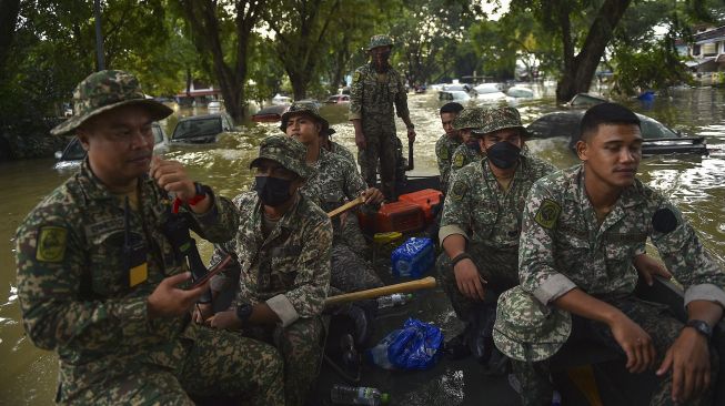 Personel militer berpartisipasi dalam misi penyelamatan untuk mengevakuasi orang-orang yang terjebak banjir di Shah Alam, Selangor, Malaysia, Senin (20/12/2021). [ARIF KARTONO / AFP]