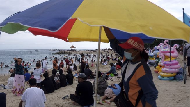 Wisatawan memadati objek wisata Pantai Sanur saat liburan di Denpasar, Bali, Minggu (19/12/2021). [ANTARA FOTO/Nyoman Hendra Wibowo]