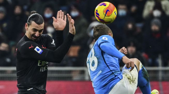 Gelandang Napoli Stanislav Lobotka (kanan) membersihkan bola di sebelah penyerang AC Milan Zlatan Ibrahimovic selama pertandingan sepak bola Serie A Italia antara AC Milan dan Napoli di stadion San Siro, Milan, pada (19/12/2021). [MIGUEL MEDINA / AFP]