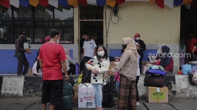 Sejumlah calon penumpang menunggu kedatangan bus di Terminal Kampung Rambutan, Jakarta, Selasa (21/12/2021). [Suara.com/Angga Budhiyanto]