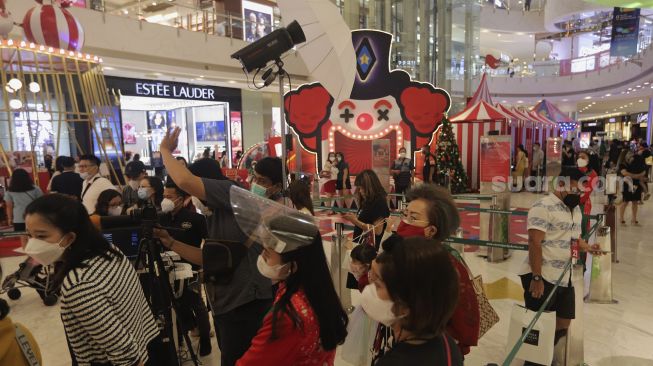 Sejumlah pengunjung mengantre untuk berfoto bersama Santa Claus di Central Park Mall, Jakarta, Selasa (21/12/2021). [Suara.com/Angga Budhiyanto]